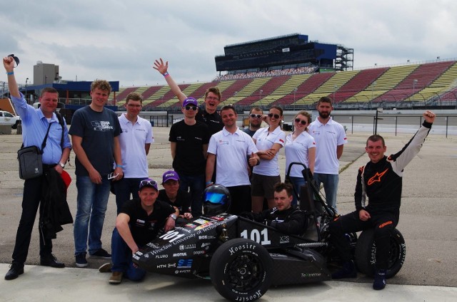 Zdjęcie teamu na torze Michigan International Speedway z opiekunami - prof. Tadeuszem Smolnickim i dr Marcinem Tkaczykiem. Członkowie zespołu: Jakub Torończak, Przemek Idzikowski, Mac Wnu, Marcin Droszczak, Marcin Wejchert, Kuba Okoński, Tomasz Filip Godlewski, Bartek Paszkiewicz, Ewa Kozłowska, Łukasz Horanin, Magdalena Klimek, Michał Wojtkowiak i Paweł Rak