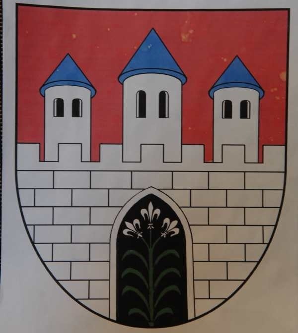 Symbol miasta - mur obronny z bramą i trzema wieżami jest w kolorze srebrnym, natomiast zakończenia dachów wież - niebieskie