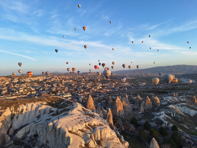 Lot balonem nad Kapadocją o wschodzie słońca. W górę wzbija się jednocześnie aż sto balonów