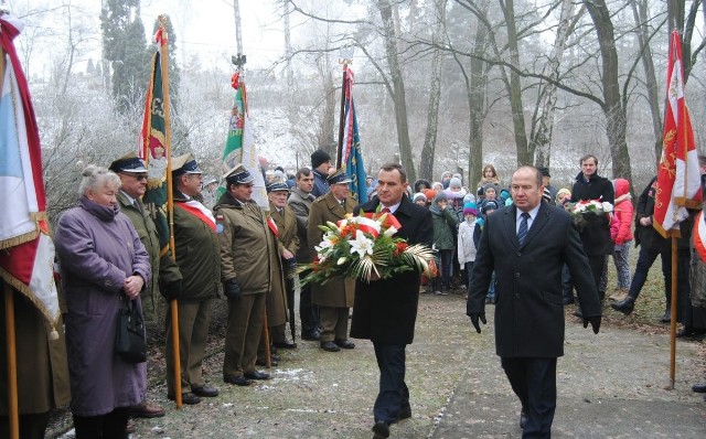 Władze samorządowe gminy Włoszczowa składają kwiaty na mogile zamordowanych mieszkańców Kurzelowa 72 lata temu.