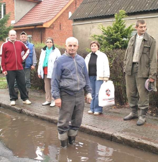 Eugeniusz Ryba (w środku) pokazuje, jak głębokie są kałuże, w które wjeżdżają rozpędzone tiry