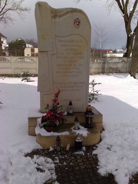 Pod pomnikiem poświęconym ofiarom zbrodni w Serbach płona znicze.