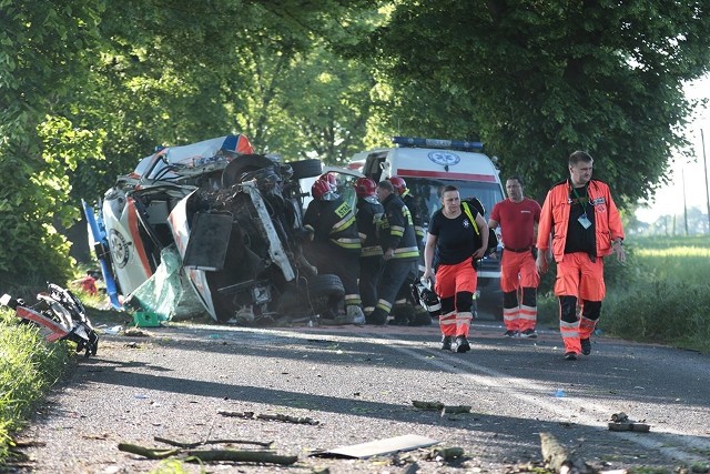 Do tragicznego wypadku doszło w środę, 9 maja, na trasie Sulechów-Kije. Rozpędzona karetka pogotowia ratunkowego uderzyła w drzewo. Zginął strażak, który był również ratownikiem medycznym. Kierowca został zabrany do szpitala śmigłowcem lotniczego pogotowia ratunkowego. Lekarzowi nic się nie stało.Do tragicznego wypadku doszło przed godz. 7.00. Najprawdopodobniej karetka pogotowia ratunkowego jechała w kierunku Sulechowa. – Z niewyjaśnionych jeszcze przyczyn kierowca karetki zjechał na przeciwległy pas ruchu i tam na poboczu uderzył w drzewo – mówi podinsp. Małgorzata Stanisławska, rzeczniczka zielonogórskiej policji.Siła uderzenia w drzewo była ogromna. Karetka została kompletnie rozbita. Przewróciła się na bok. Ma zmiażdżony przód. Na miejsce natychmiast dojechały służby ratunkowe. Niestety w wypadku zginęła jedna osoba. To strażak zawodowy i zarazem ratownik medyczny. Ranny kierowca został zabrany do szpitala śmigłowcem pogotowia ratunkowego. To strażak ochotnik. Lekarz z karetki wyszedł o własnych siłach. Nie doznał poważniejszych obrażeń.Droga w miejscu wypadku jest zablokowana. Pracują tu policjanci z zielonogórskiej drogówki oraz prokurator, którzy mają wyjaśnić dokładny przebieg zdarzenia. W tragicznym wypadku zginął strażak zawodowy z JRG nr 1 w Zielonej Górze. – To wielka starta i smutek dla całego lubuskiego garnizonu straży pożarnej – mówi mł. bryg. Ryszard Gura, rzecznik zielonogórskich strażaków. Strażak, który zginął w wypadku był świetnym pracownikiem i członkiem grupy ratowników wysokościowych. W kraju był znanym przewodnikiem psów tropiących, który profesjonalnie zajmował się ich szkoleniami.Do tragicznego wydarzenia odniósł się także Janusz Kubicki. - To bardzo trudne, kiedy umiera w wypadku ktoś, kto ryzykuje własnym życiem, żeby pomóc innym - skomentował  Janusz Kubicki. Prezydent Zielonej Góry dodał również, że wypadku mogłoby nie być, gdyby nie gęsto posadzone przy drodze drzewa. - Czasami chciałbym je wszystkie powycinać. Te drzewa sadzono, kiedy jeżdżono bryczką, a teraz poruszamy się samochodami i są to po prostu niebezpieczne miejsca - uważa prezydent miasta. Zobacz też wideo: KRYMINALNY CZWARTEK - 3.05.2018 - Werbowali kobiety, zmuszali je do prostytucji. Uczynili sobie z tego stałe źródło dochodu. Zatrzymała ich lubuska policja