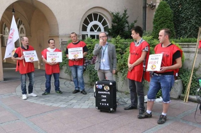 Związkowcy na plakatach wypisali wynagrodzenia za pracę  w Polsce i innych krajach unijnych.