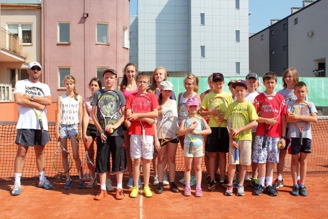 Młodzi adepci tenisa ziemnego z trenerem Bartoszem Nowakiem.