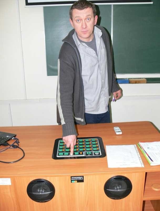 Dyrektor Janusz Maciejewski pokazuje pulpit nauczyciela w nowej sali językowej.