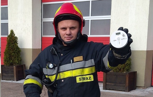 Młodszy ogniomistrz Łukasz Kacprzak z Jednostki-Ratowniczo Gaśniczej Państwowej Straży Pożarnej w Białobrzegach prezentuje czujnik czadu, który można zainstalować w mieszkaniu.