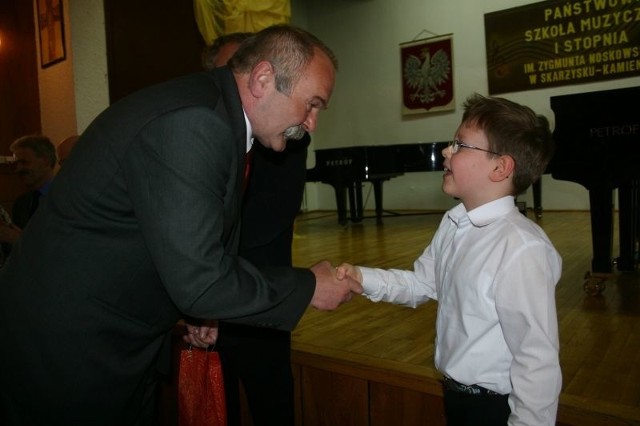 Sekretarz miasta Jan Janiec wręcza nagrodę najmłodszemu uczestnikowi konkursu - dziewięcioletniemu Wojciechowi Pondo z Warszawy.