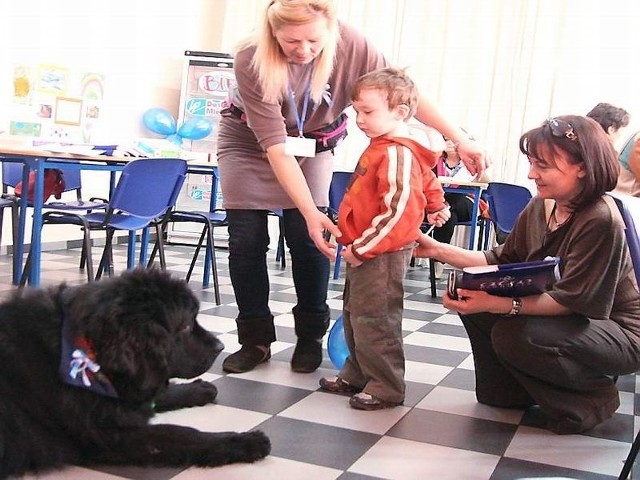 Dogoterapeutka Ewa Grabowska pokazuje Adrianowi, jak postępować z psem. Z prawej terapeutka Magdalena Rekowska