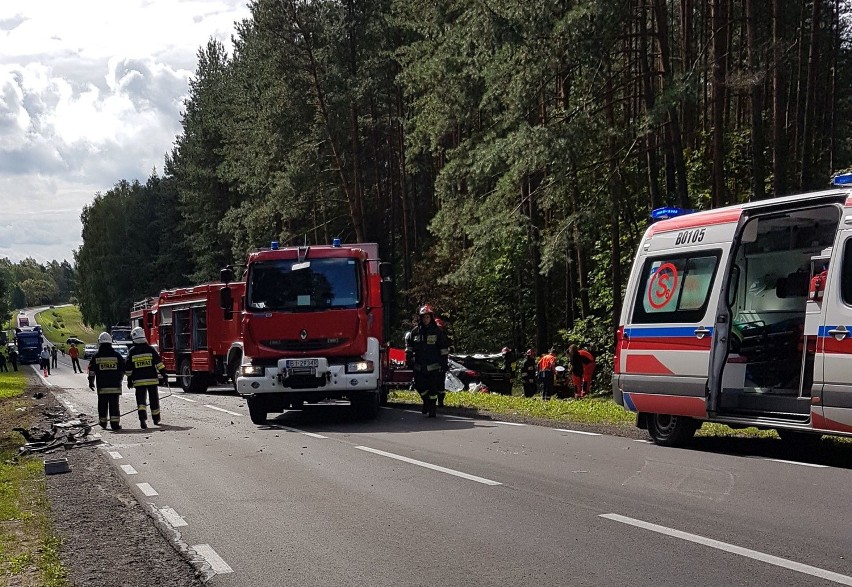 Na miejscu pracują strażacy, policja i pogotowie. Droga jest...