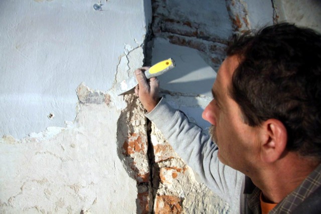 Konserwator Jerzy Smyk  podczas pracy przy północnej ścianie kościoła na Czwartku