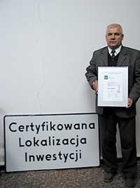 Wójt Kozłowski z dyplomem i tablicą, która zawiśnie na budynku Urzędu Gminy