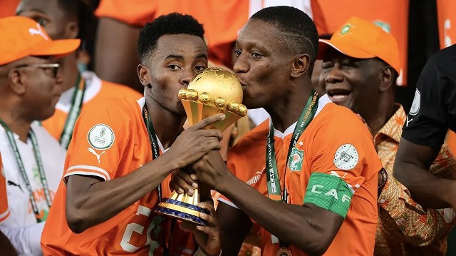 Reprezentanci Wybrzeża Kości Słoniowej całują trofeum Pucharu Narodów Afryki – lewoskrzydłowy Simon Adingra (Brighton & Hove Albion) oraz prawy obrońca i kapitan Serge Aurier (Nottingham Forest)