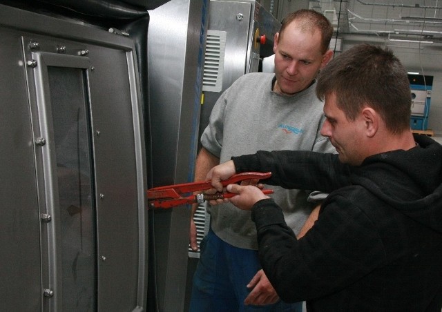 Albert Wajske i Przemysław Jopek pracują przy montowaniu pralek w nowym zakładzie. Zaznacza, że to bardzo nowoczesne urządzenia.