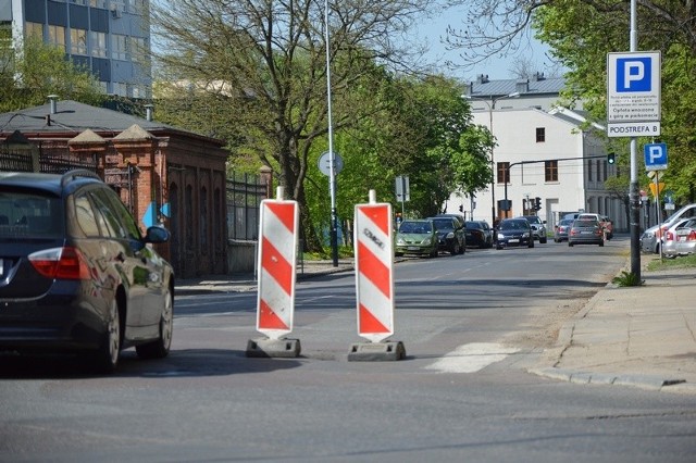 Dziury w jezdni ul. Tymienieckiego strzegą dwa słupki.