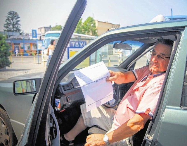 Taksówkarz Marian Krupa pokazuje wezwanie do zapłaty kwoty prawie 300 zł za wynajem miejsca postojowego.