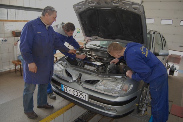 Samuel Witek i Paweł Targun, uczniowie II klasy Technikum Mechanicznego wykonują badanie techniczne pojazdu pod kierunkiem nauczyciela Tadeusza Miazgi.