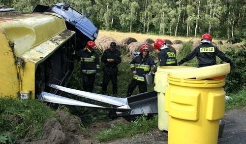 Po wypadku cysterny na krajowej "szóstce", strażacy zbierają wyciekające paliwo do specjalnych pojemników. Cysterna w momencie wypadku w zbiornikach miała 30 tys. litrów oleju napędowego.