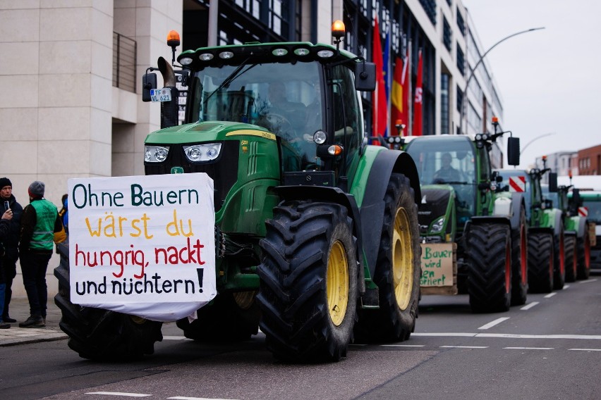 Transparent protestujących rolników w Berlinie głosi: "Bez...