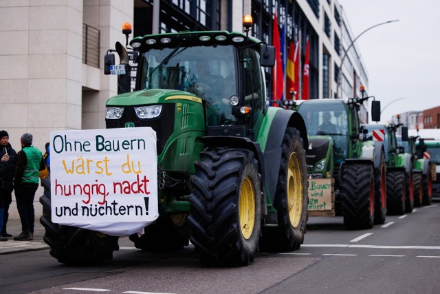 Transparent protestujących rolników w Berlinie głosi: "Bez rolników bylibyście głodni, goli i trzeźwi!".