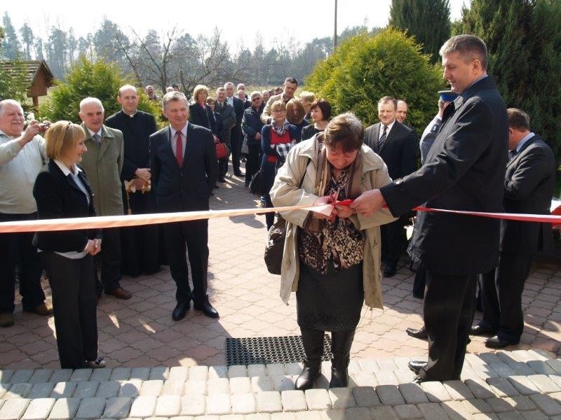 Mama jednego z podopiecznych ŚDS przecina wstęgę