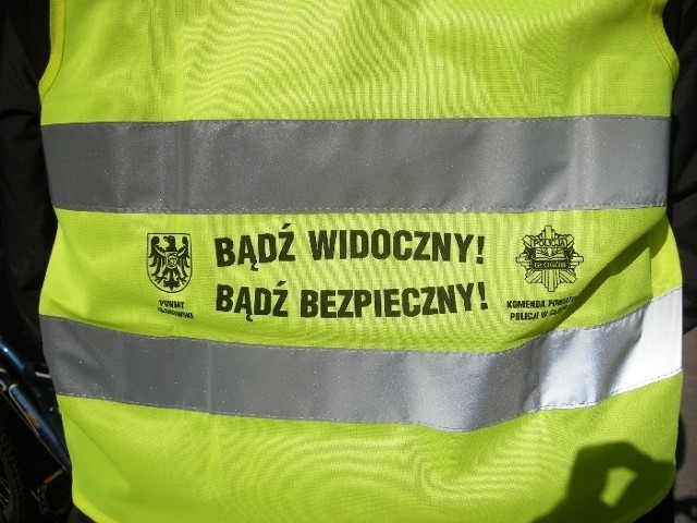 Głogowscy policjanci rozdają rowerzystą takie kamizelki.