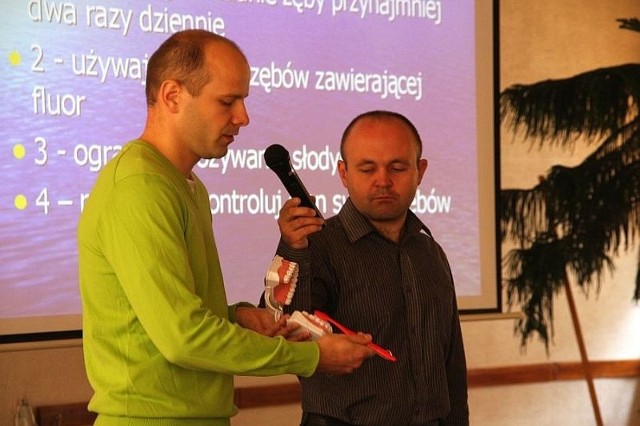 Lekarz stomatolog Robert Frączyk i Marcin Szyposzyński pokazuja, jak prawidłowo myć zęby