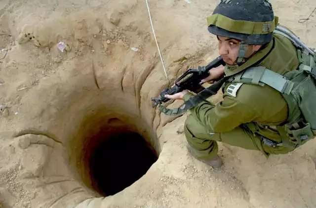 Na fotografii udostępnionej 18 bm. przez izraelskie Ministerstwo Obrony: żołnierz izraelski przy tunelu odkrytym na jednym z gospodarstw rolnych w Gazie, przy granicy z Egiptem