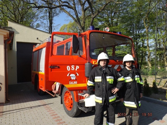 Strażacy z OSP w Żalnie - Metody Guss i Piotr Michalak na tle samochodu i remizy.