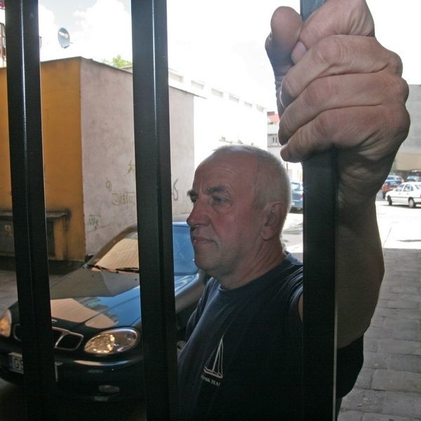 Andrzej Grzybowski przy bramie, która może doprowadzić do upadku jego firmę.