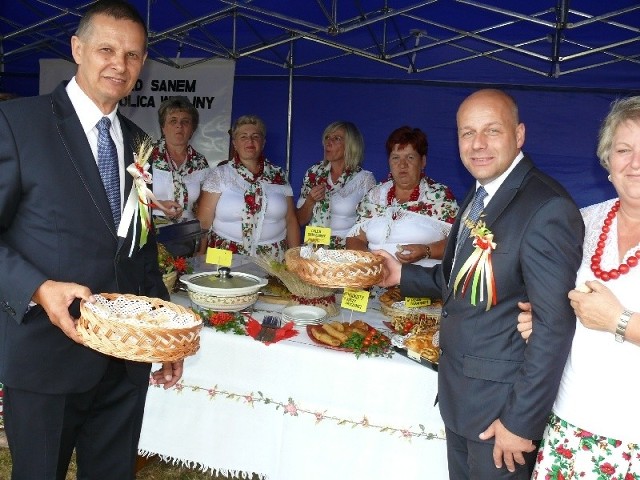 Dwóch starostów - dożynek (z lewej) Tomasz Kozak i starosta niżański Robert Bednarz, dzielą się chlebem z kobietami.