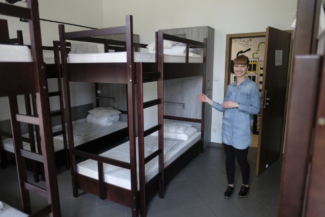 Pani Dominika prezentuje warunki pobytu w jednym z pokoi znajdujących się w hostelu Toruń Główny