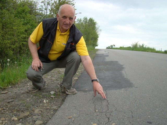 Andrzej Kramarczyk pokazuje pęknięcia na drodze z Łękawicy do Stryszowa, jakie powstały przez ciężkie pojazdy