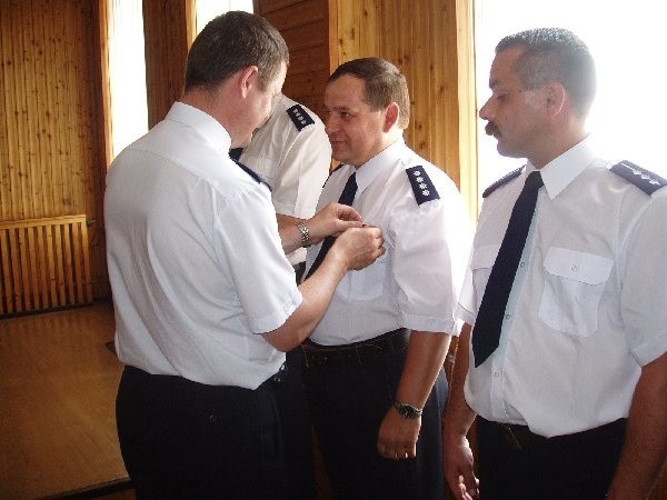 Nadkomisarz Edward Pepliński otrzymał  brązową odznaką "Zasłużony policjant". Wręcza  komendant powiatowy Krzysztof Bodziński.