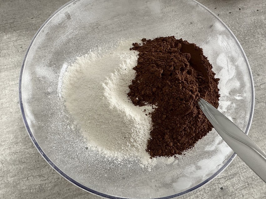 Zacznij od upieczenia spodu ciasta. Wymieszaj mąkę z kakao....