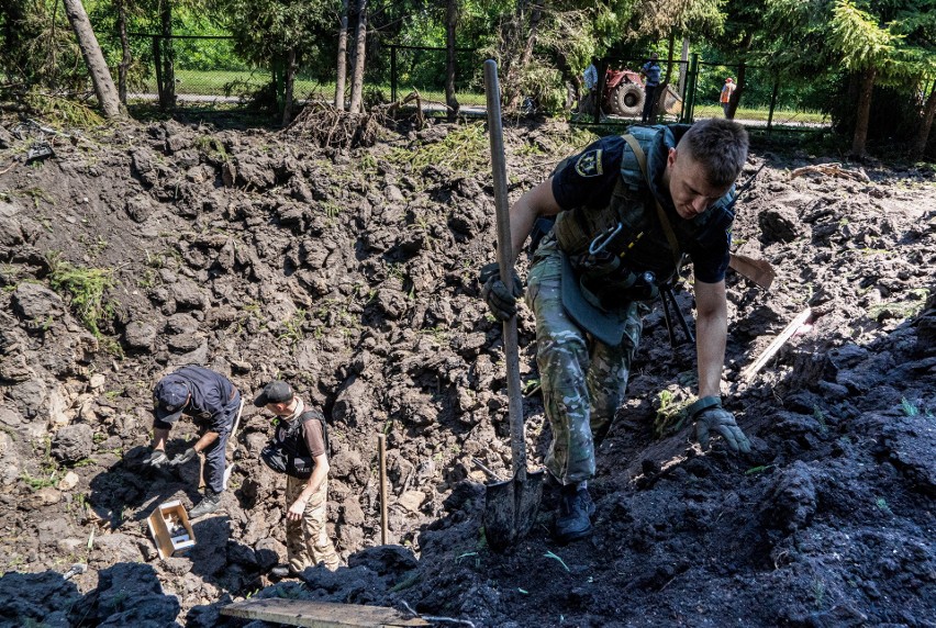 Ukraińscy żołnierze szukają fragmentów rosyjskiego pocisku,...