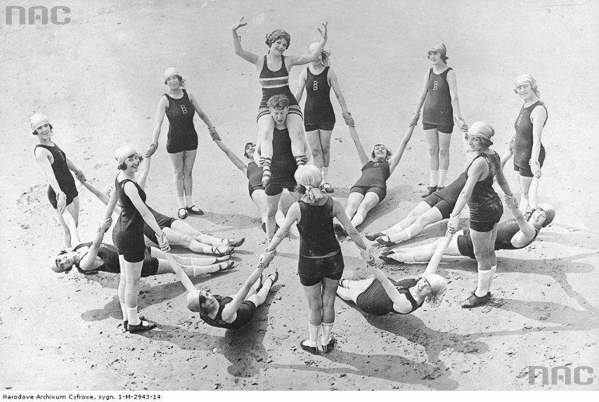 Grupa osób w kostiumach kąpielowych podczas zabawy na plaży