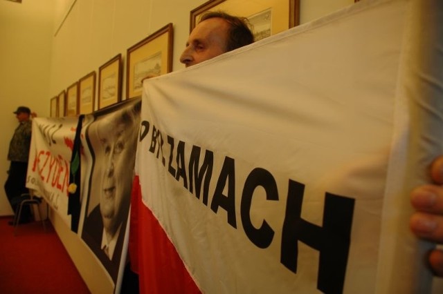 Mieczysław Herbrych z biało-czerwoną flagą z napisem "To był zamach&#8221; w czasie spotkania w Gorzowie w 2011 r. Był także z flagą na pogrzebie Anny Walentynowicz w Gdańsku.