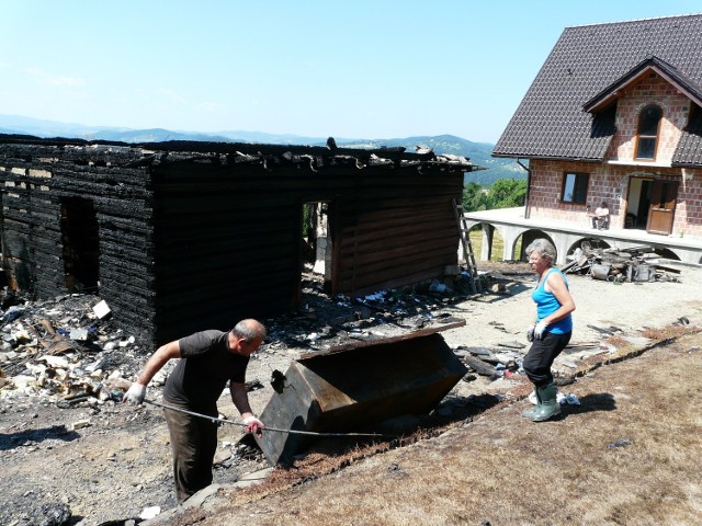 Krystyna Maciaszek podczas sprzątania po pożarze. W tyle nowo budowany dom