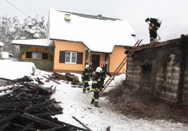 Najbliższa rodzina nie była w stanie pomóc kobiecie. W tle spalonego budynku dom, w którym mieszka syn zmarłej.