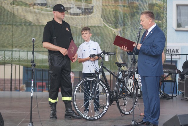 Od lewej: Łukasz Wojsa, Wiktor Wojsa oraz burmistrz Chęcin Robert Jaworski. Wiktor Wojsa trzyma rower, który dostał w nagrodę od władz gminy za świetny wynik w ogólnopolskim etapie Turnieju Wiedzy Pożarniczej.