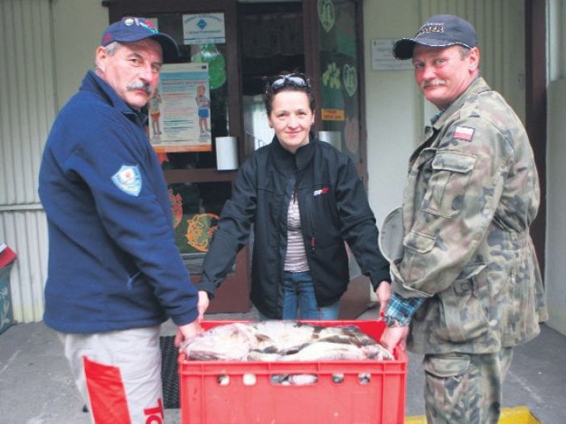 Beata Janiszewska, dyrektorka Przedszkola nr 3, odbiera ryby odwędkarzy Andrzeja Głucha (z lewej) i Dariusza Nowackiego.