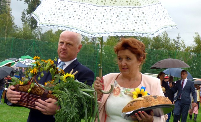 Deszczowe dożynki w Czarnocinie. Pod parasolem maszerowali także w korowodzie starostowie - Elżbieta Latos i Janusz Kowalski.