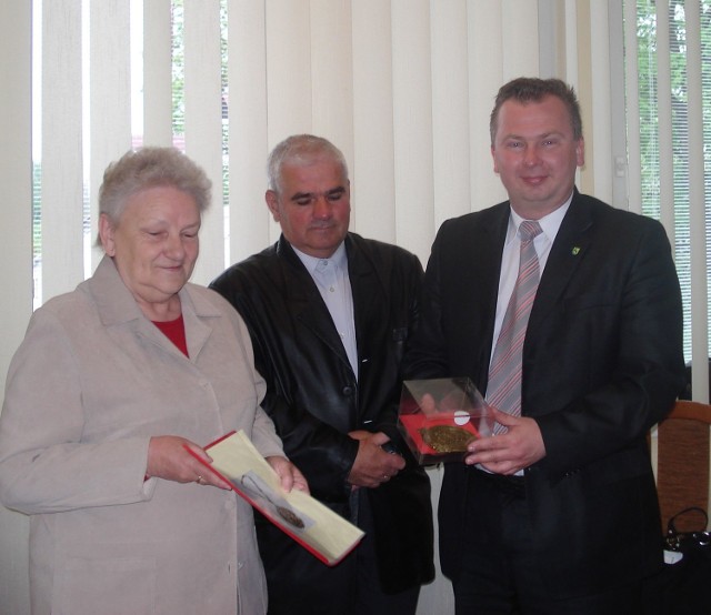 Wójt gminy Bliżyn Mariusz Walachnia przyjmuje z rąk Krystyny Skowron odnaleziony medalion wójta Bliżyna z lat 20 - tych ubiegłego wieku.