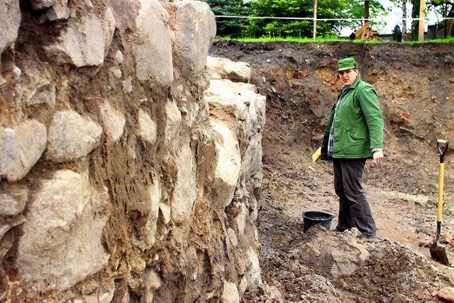 Archeolog Łukasz Trzciński przy murach