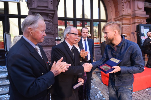 Prof. Marian Filar i Tomasz Organek odsłaniają katarzynki w Piernikowej Alei Gwiazd w Toruniu