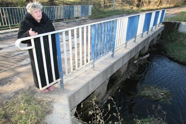 Janina Gylaka z trwogą patrzy na rzekę. Boi się, że z powodu zatkanego przepustu znów woda wyleje się z koryta.