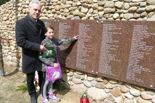 Syn i prawnuczka hubalczyka szeregowego Zenona Kądzieli przy Ścianie Pamięci z nazwiskami hubalczyków