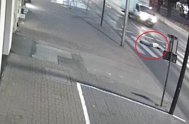 Policja opublikowała nagranie z monitoringu, na którym widać, jak nieznany mężczyzna, znajdując się na oznakowanym przejściu dla pieszych kładzie się na wznak na jezdni.