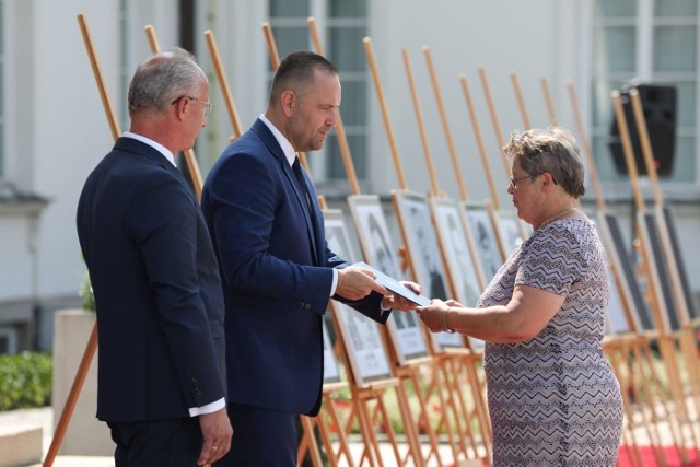 Janina Ptak, siostrzenica Stanisława Zyskowskiego odbiera notę identyfikacyjną z rąk prezesa IPN Karola Nawrockiego i wiceprezesa Krzysztofa Szwagrzyka.